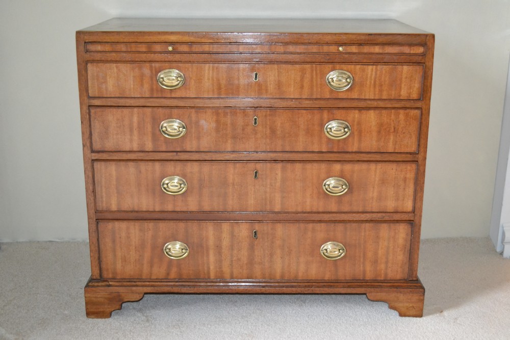 A very good small Sheraton mahogany chest of drawers with brushing slide.