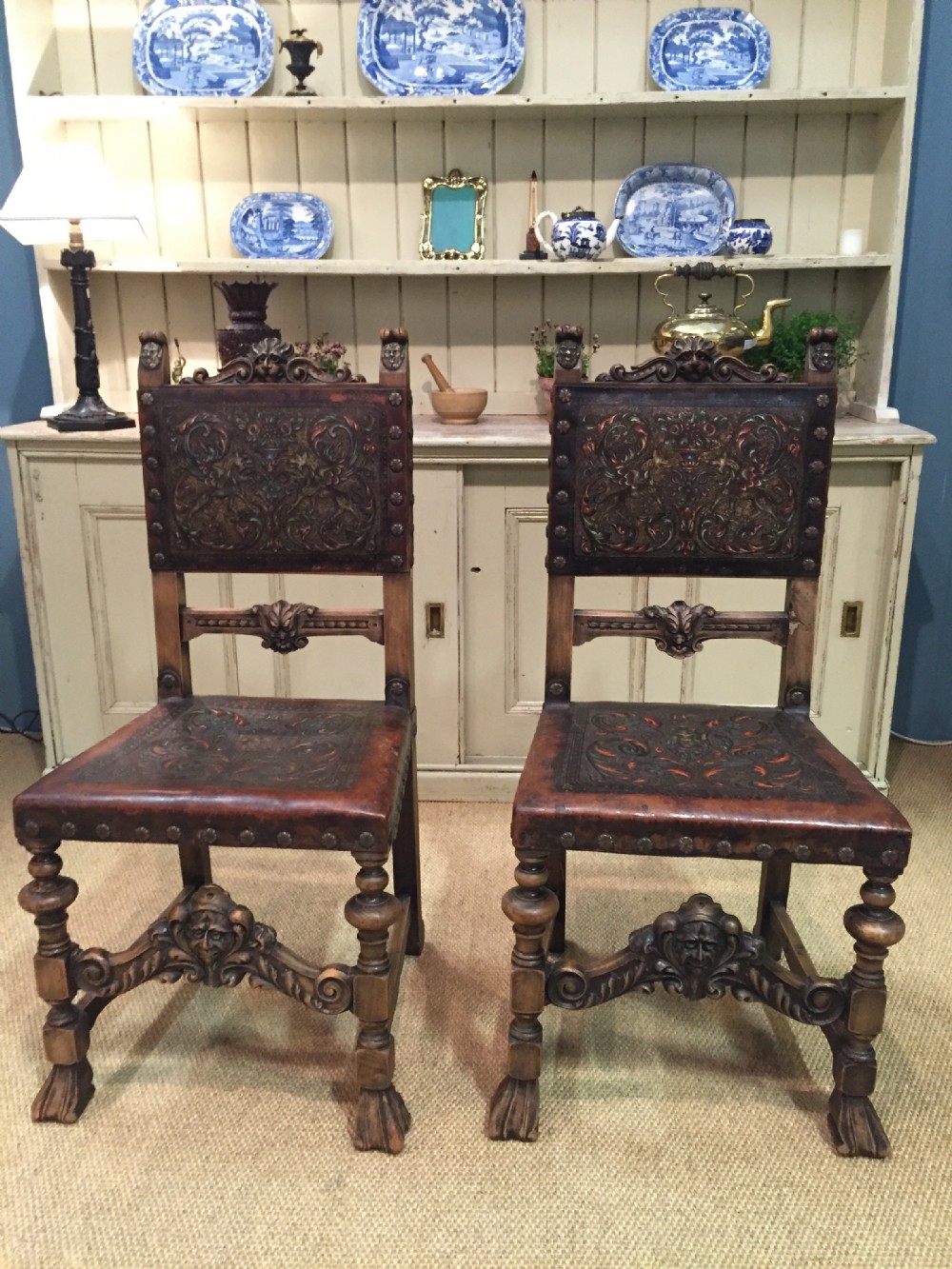 Pair of 17th century style carved walnut and embossed leather chairs 