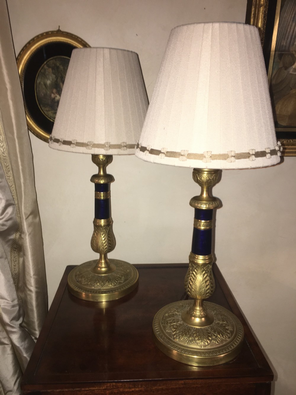A pair of gilt brass Empire style table lamps with dark blue central columns and pleated cream fabric shades. View II