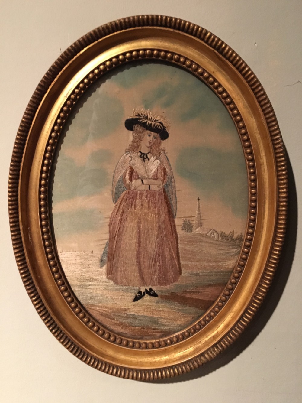 An 18th-century oval needlework picture featuring a lady in Georgian costume framed in a beaded water-gilded wood frame. View II