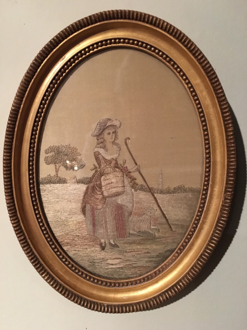 An 18th-century oval needlework picture featuring a lady in Georgian costume framed in a beaded water-gilded wood frame. View III