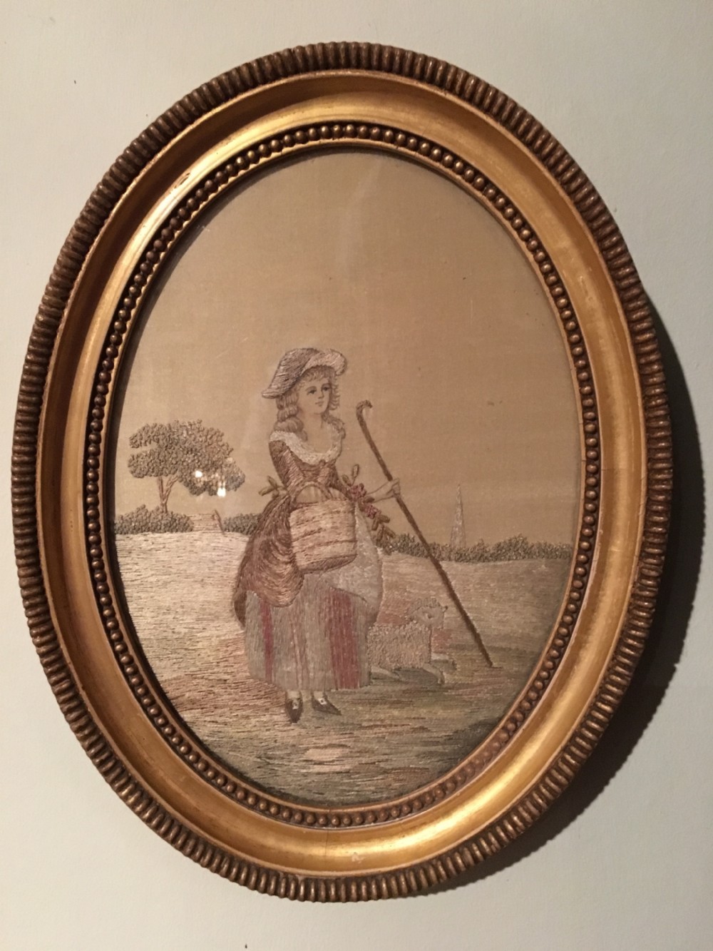An 18th-century oval needlework picture featuring a lady in Georgian costume framed in a beaded water-gilded wood frame. View V