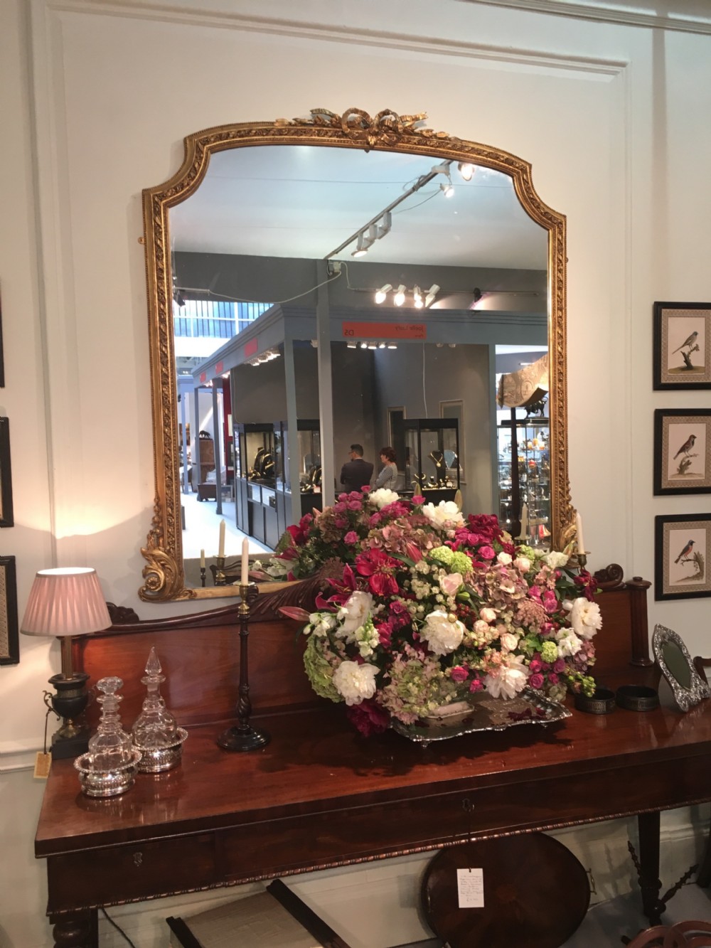 A large 19th-century giltwood overmantel mirror featuring an arched top frame detailed with a carved ribbon cresting.