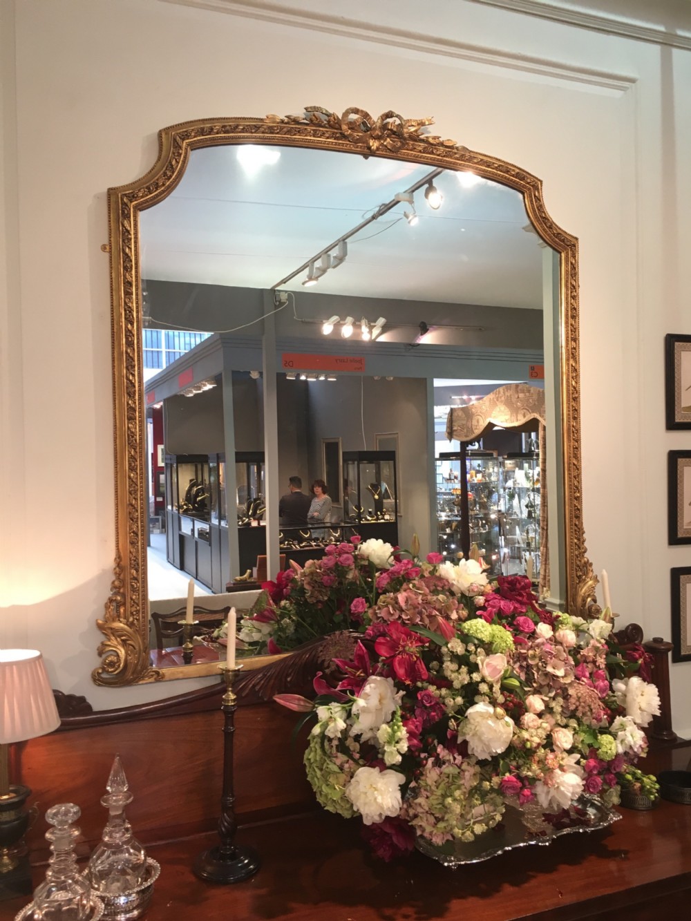 A large 19th-century giltwood overmantel mirror featuring an arched top frame detailed with a carved ribbon cresting. View II