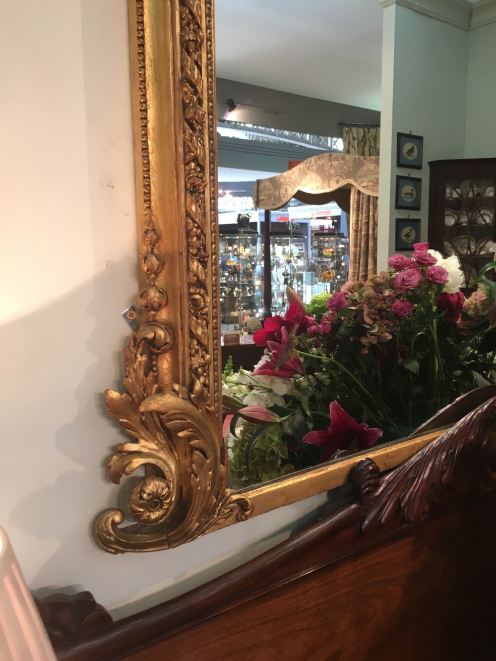A large 19th-century giltwood overmantel mirror featuring an arched top frame detailed with a carved ribbon cresting. View III