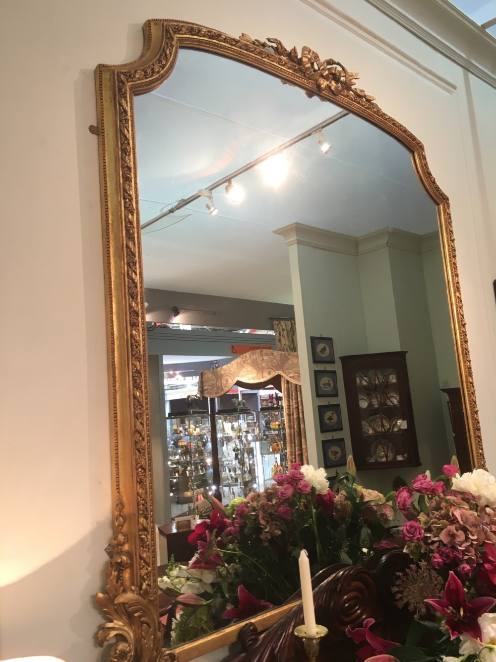 A large 19th-century giltwood overmantel mirror featuring an arched top frame detailed with a carved ribbon cresting. View IV