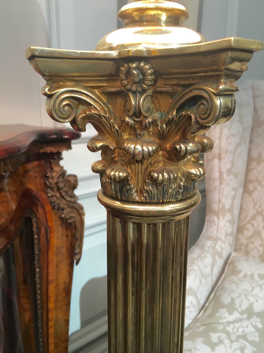 A brass telescopic standard lamp featuring a fluted column stem, Corinthian capital detail, a square stepped base with ornate feet, and a pleated white shade. View VIII