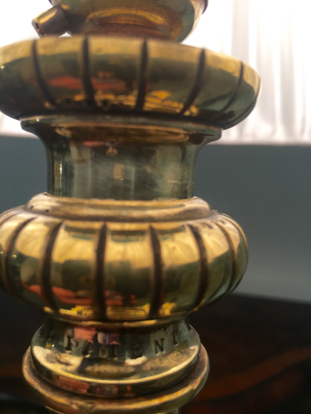 A brass telescopic standard lamp featuring a fluted column stem, Corinthian capital detail, a square stepped base with ornate feet, and a pleated white shade. View IX