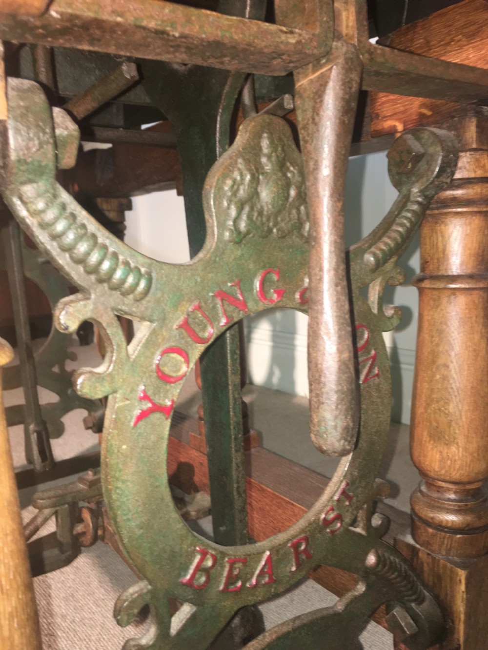 An antique oak jockey scale chair by Young & Son featuring turned legs, rear wheels, a brass balance mechanism, and a set of bell-shaped brass weights. View XI