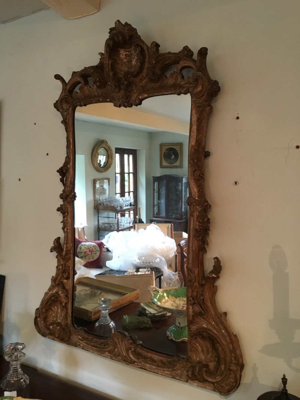 An 18th-century Chippendale giltwood pier mirror featuring an intricately carved Rococo frame with C-scrolls, acanthus leaf motifs, and an ornamental cresting.