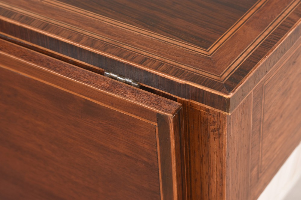 An 18th-century Sheraton rosewood sewing table featuring a top drawer, a suspended cream pleated fabric work bag, square tapered legs, and brass castors. View III