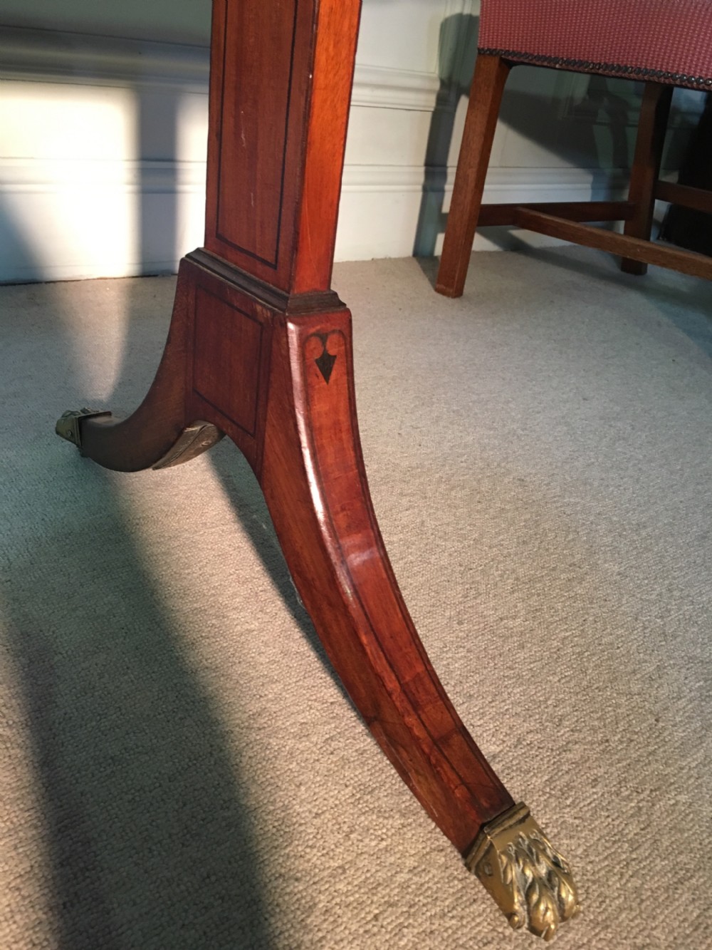 A Georgian mahogany sofa table with two drop leaves, front drawers with brass knobs, and splayed legs ending in brass claw castors. View IX