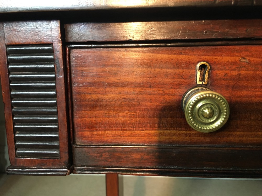 A Georgian mahogany sofa table with two drop leaves, front drawers with brass knobs, and splayed legs ending in brass claw castors. View X