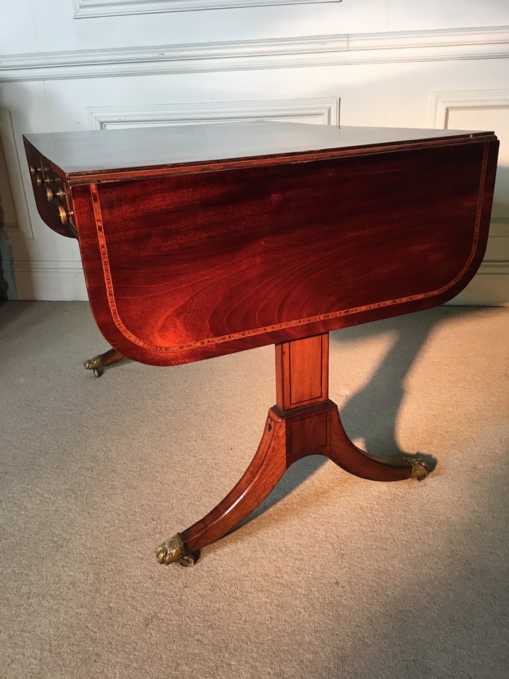 A Georgian mahogany sofa table with two drop leaves, front drawers with brass knobs, and splayed legs ending in brass claw castors. View XI