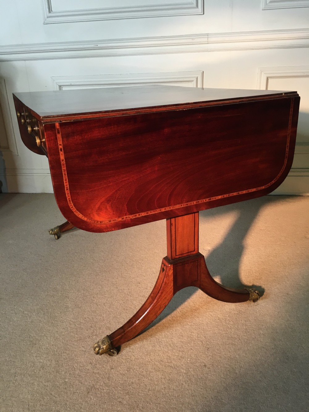 A Georgian mahogany sofa table with two drop leaves, front drawers with brass knobs, and splayed legs ending in brass claw castors. View XII