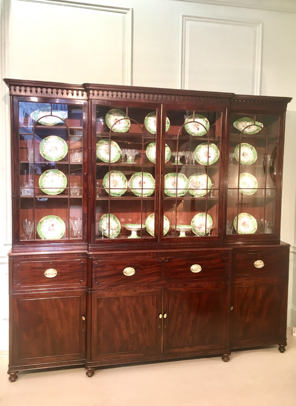 A large Georgian mahogany breakfront bookcase with four upper glazed doors and lower cupboards.
