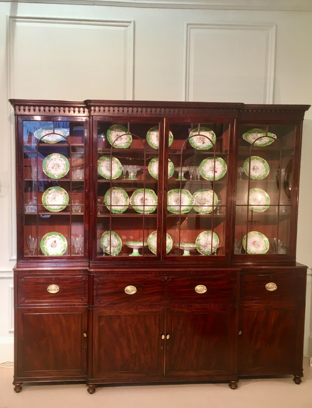 A large Georgian mahogany breakfront bookcase with four upper glazed doors and lower cupboards. View II