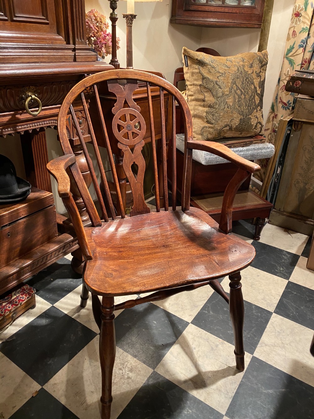 A set of antique wooden Windsor dining chairs featuring hoop backs, wheelback carved splats, spindle supports, shaped saddle seats, and turned legs. View III