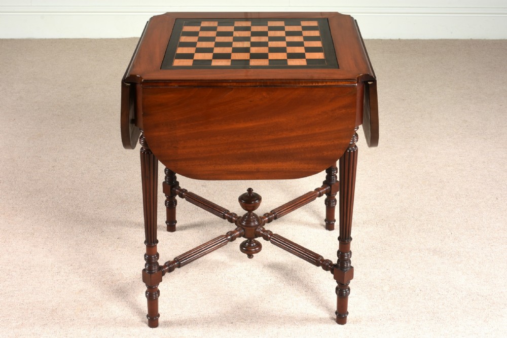 A 19th-century mahogany games table featuring a square top with an inlaid chessboard, two drop-leaf sides, reeded turned legs, and an X-stretcher with a central finial. View III