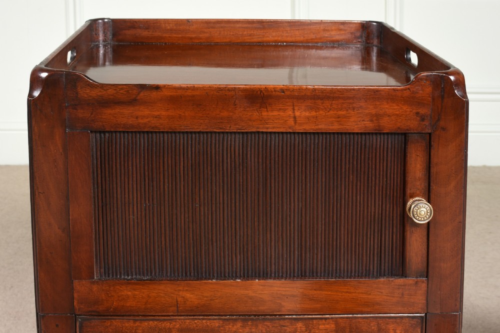 A pair of 18th-century George III mahogany bedside commodes featuring tray tops with handles, tambour shutter doors, and brass drawer handles. View III