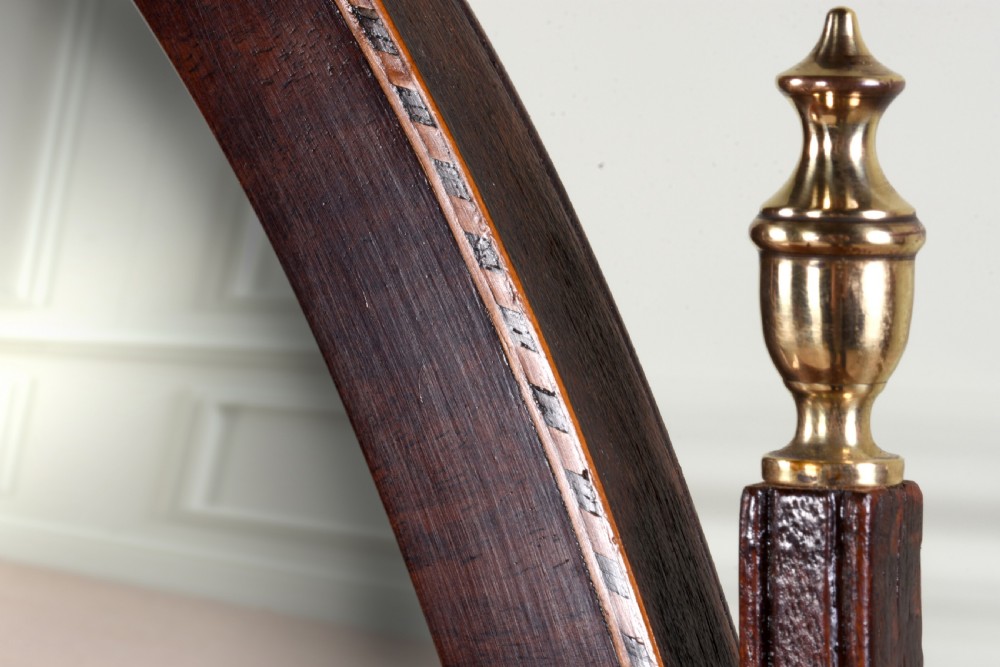 An antique George III mahogany dressing table mirror featuring an oval swing glass on curved supports above a serpentine base with three inlaid drawers. View VI