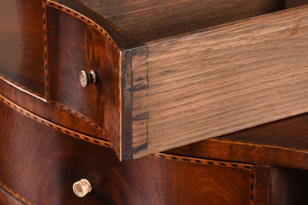 An antique George III mahogany dressing table mirror featuring an oval swing glass on curved supports above a serpentine base with three inlaid drawers. View VIII