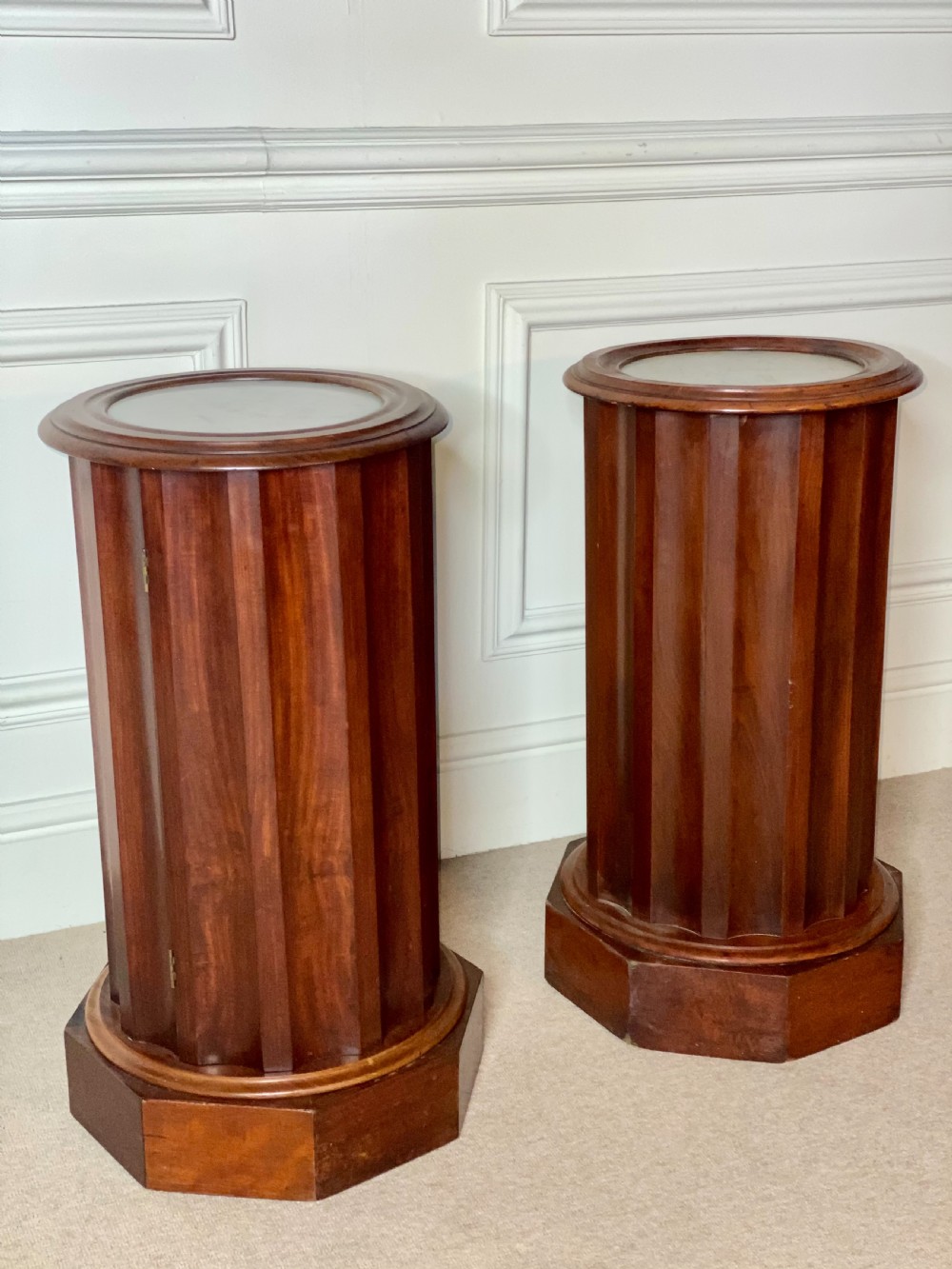 A pair of cylindrical mahogany bedside stands featuring fluted wooden columns, inset marble tops, and octagonal plinth bases. View II
