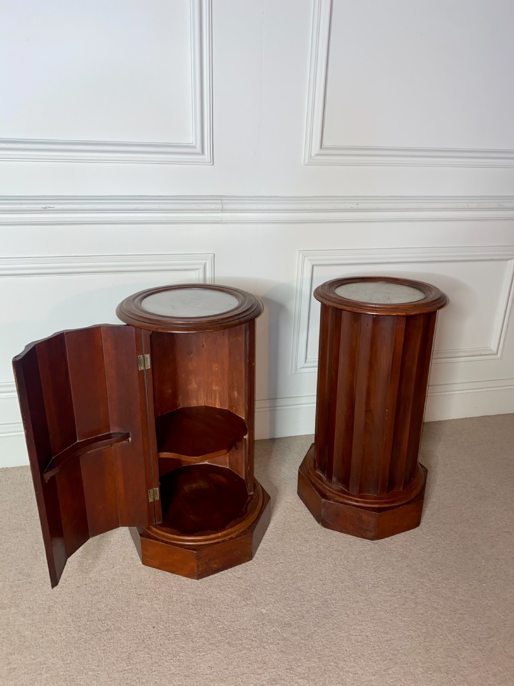 A pair of cylindrical mahogany bedside stands featuring fluted wooden columns, inset marble tops, and octagonal plinth bases. View VI