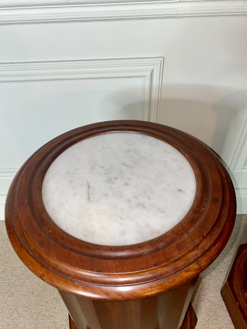 A pair of cylindrical mahogany bedside stands featuring fluted wooden columns, inset marble tops, and octagonal plinth bases. View VII