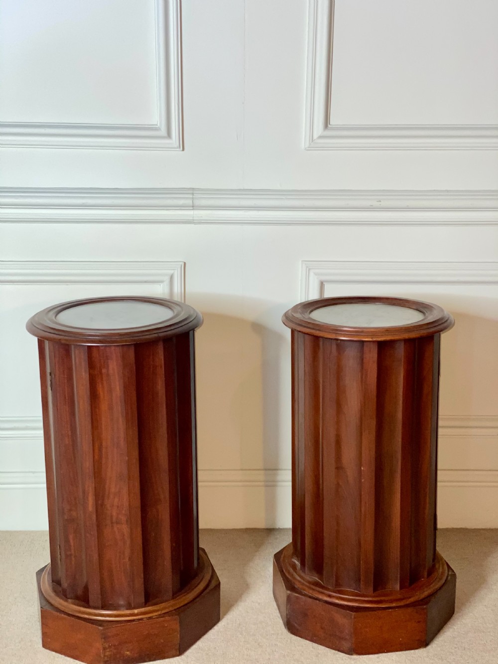 A pair of cylindrical mahogany bedside stands featuring fluted wooden columns, inset marble tops, and octagonal plinth bases. View VIII