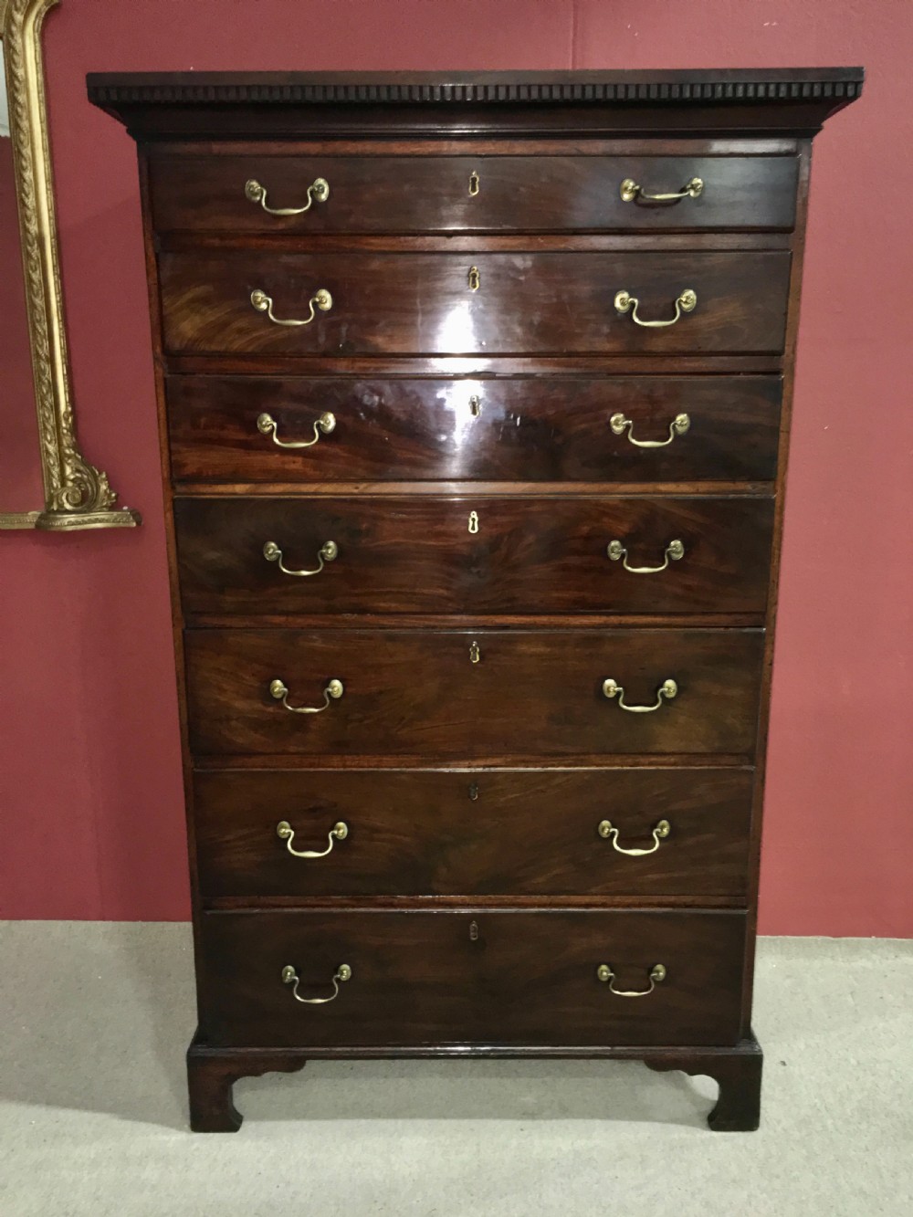 A tall George III mahogany secretaire tallboy featuring seven graduated drawers, brass swan-neck handles, dentil moulding, and bracket feet. View II