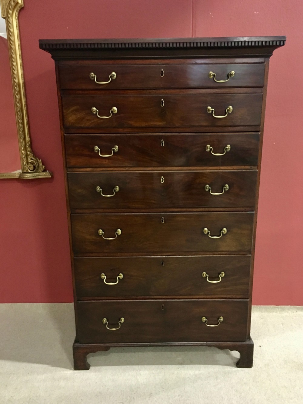 A tall George III mahogany secretaire tallboy featuring seven graduated drawers, brass swan-neck handles, dentil moulding, and bracket feet. View VI