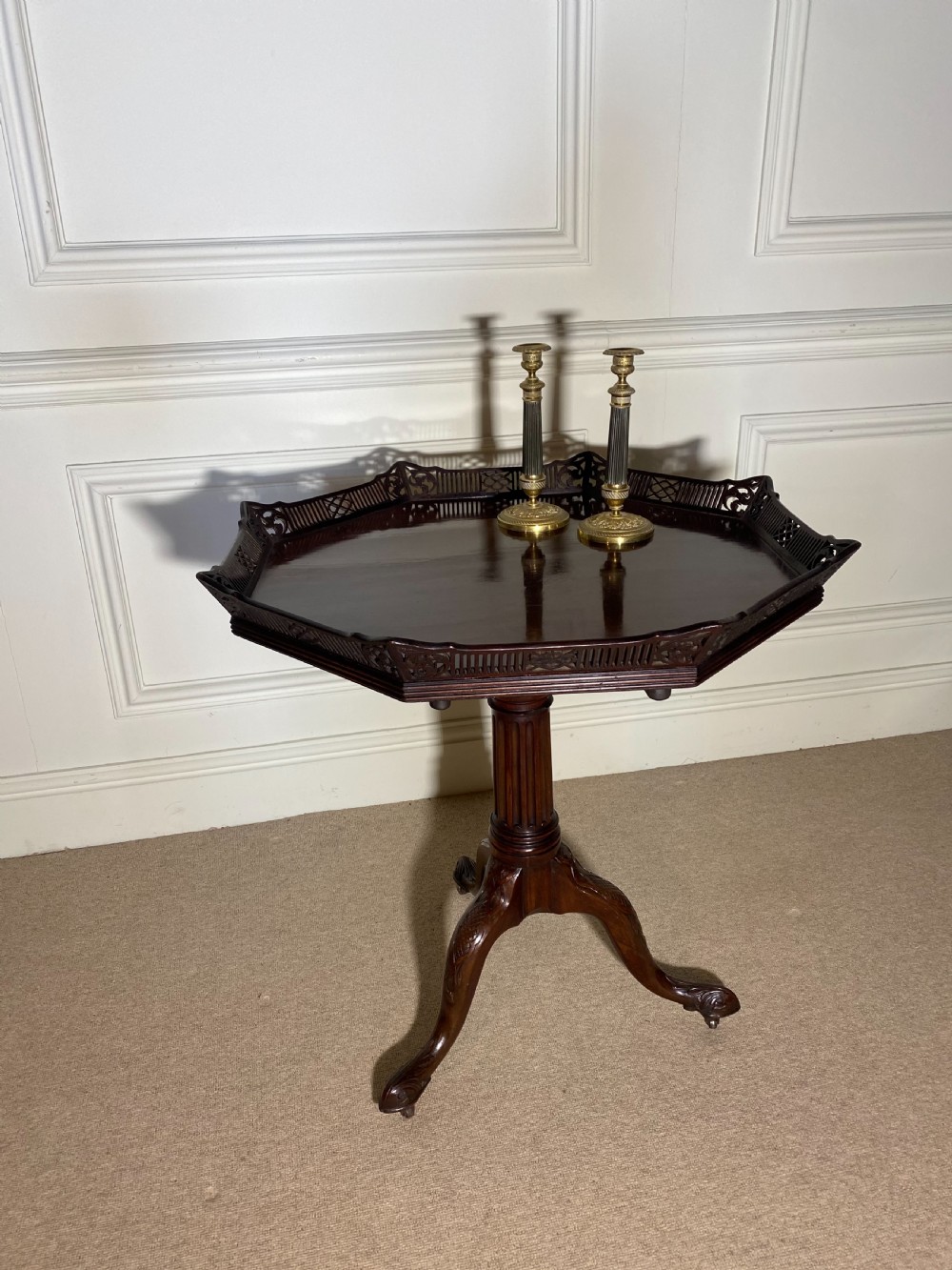 An 18th-century mahogany octagonal tripod table featuring a pierced fretwork gallery, fluted central column, and carved cabriole legs. View V
