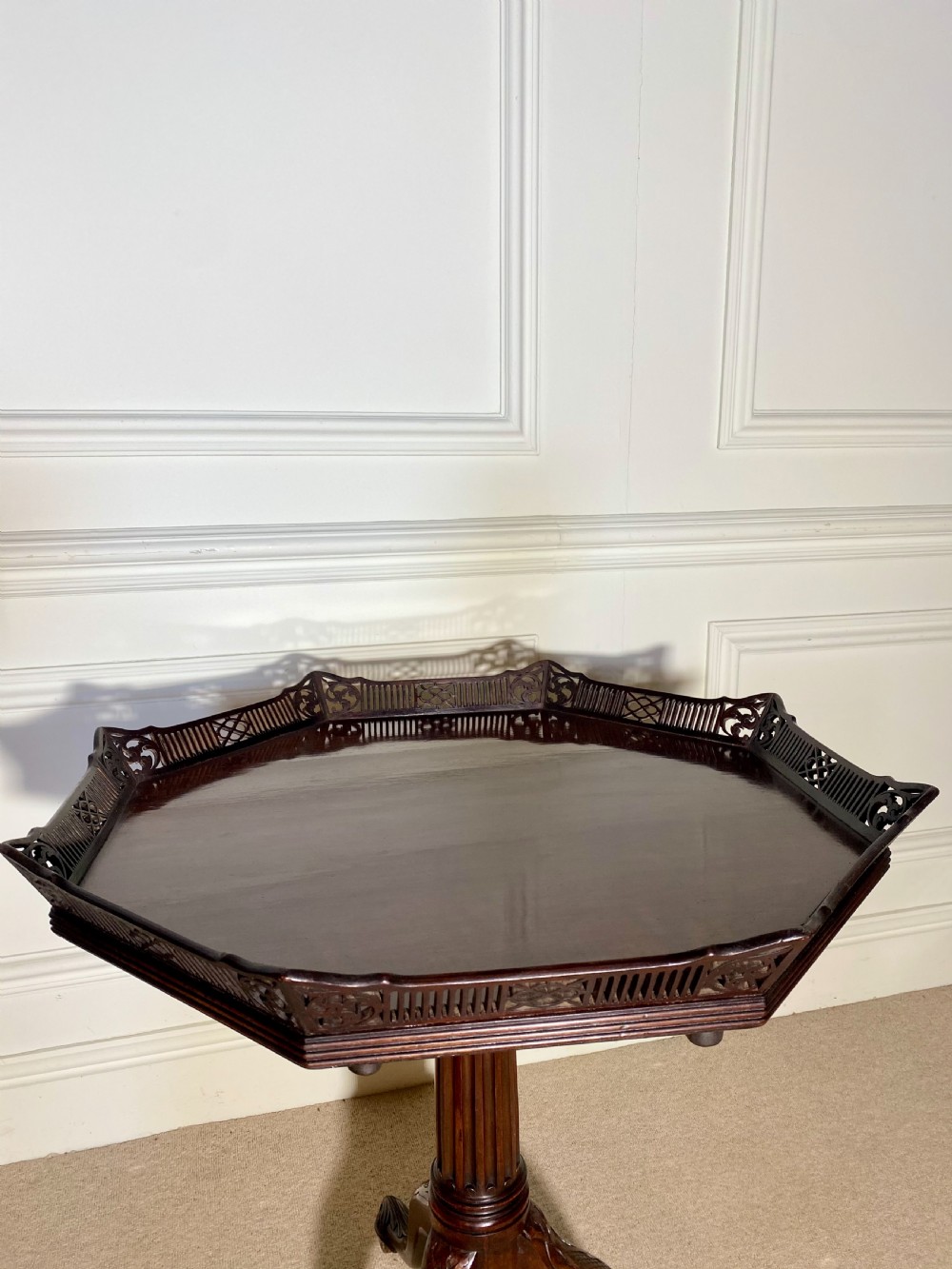 An 18th-century mahogany octagonal tripod table featuring a pierced fretwork gallery, fluted central column, and carved cabriole legs. View VI
