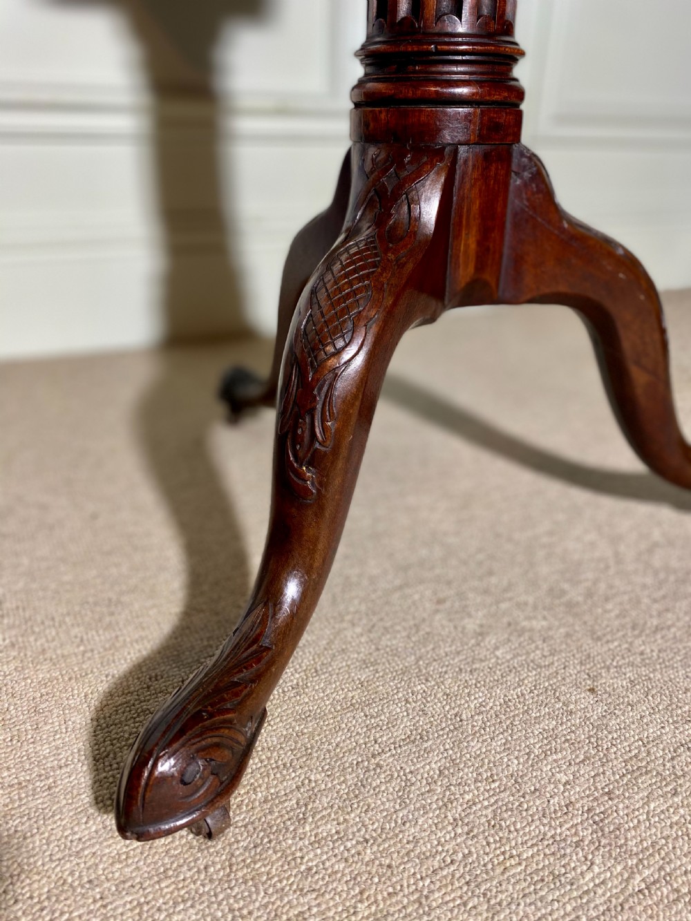 An 18th-century mahogany octagonal tripod table featuring a pierced fretwork gallery, fluted central column, and carved cabriole legs. View X