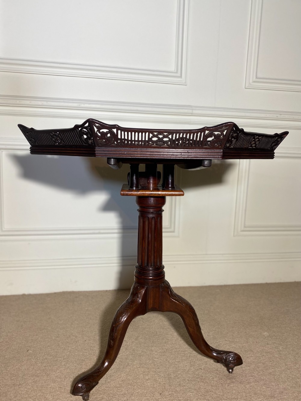 An 18th-century mahogany octagonal tripod table featuring a pierced fretwork gallery, fluted central column, and carved cabriole legs. View XVII