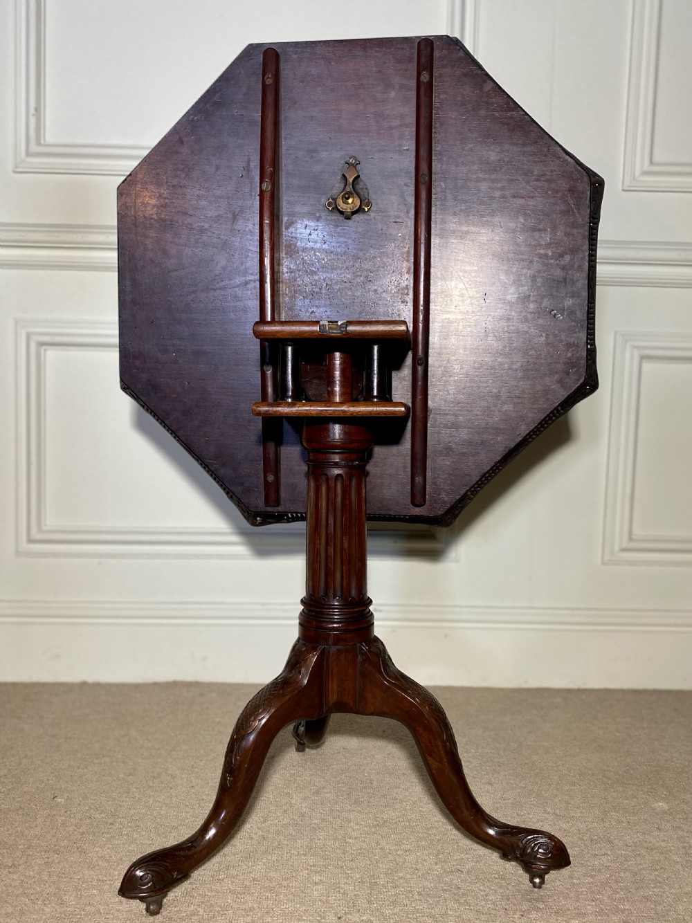 An 18th-century mahogany octagonal tripod table featuring a pierced fretwork gallery, fluted central column, and carved cabriole legs. View XVIII