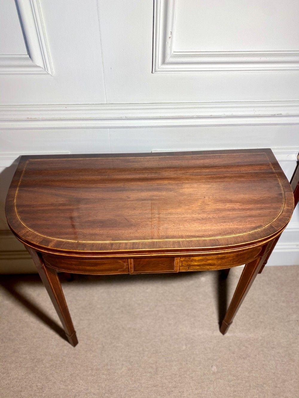 A pair of 18th-century George III mahogany demilune card tables with satinwood crossbanding, boxwood stringing, and square tapered legs. View VI