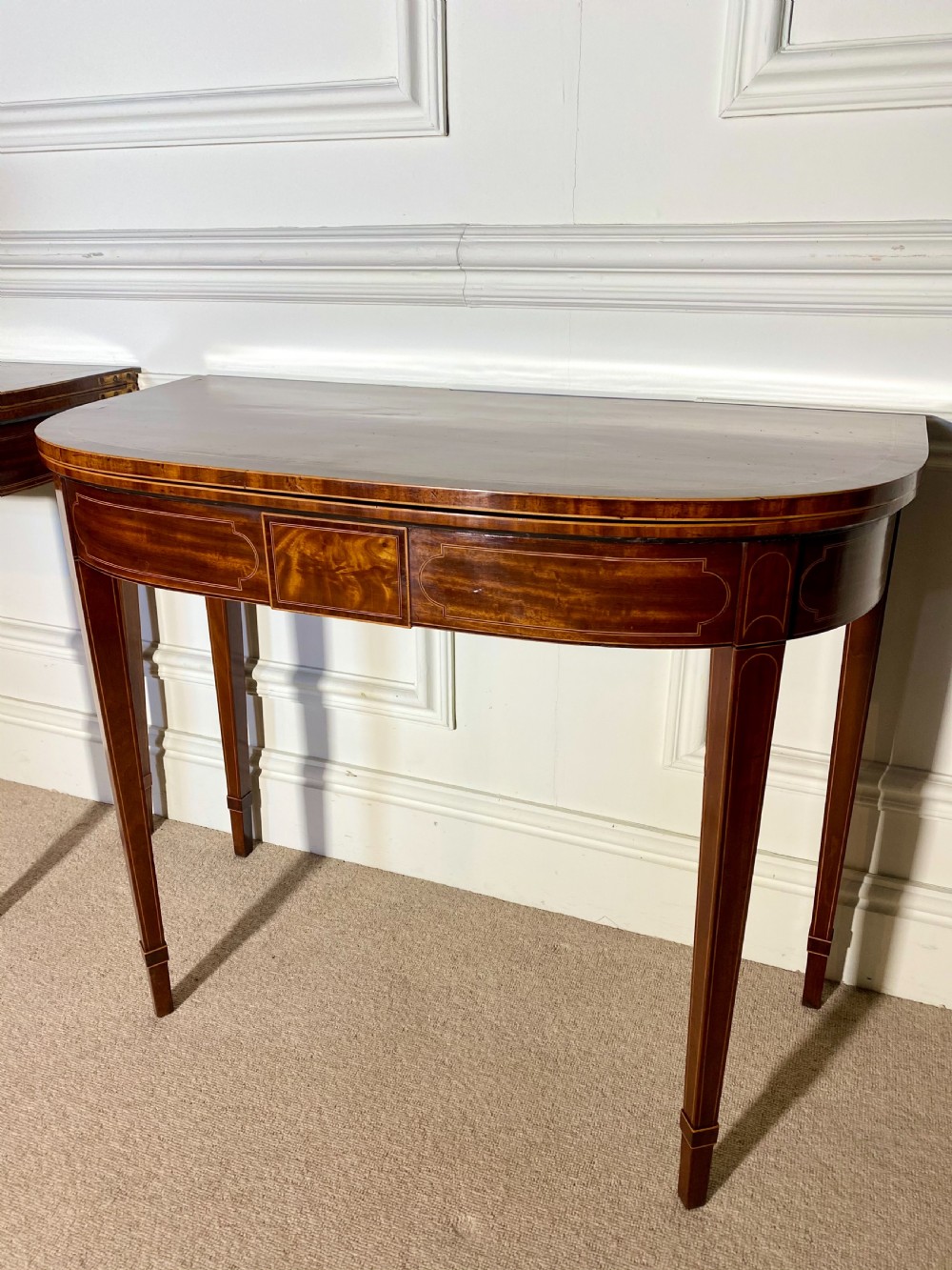 A pair of 18th-century George III mahogany demilune card tables with satinwood crossbanding, boxwood stringing, and square tapered legs. View IX