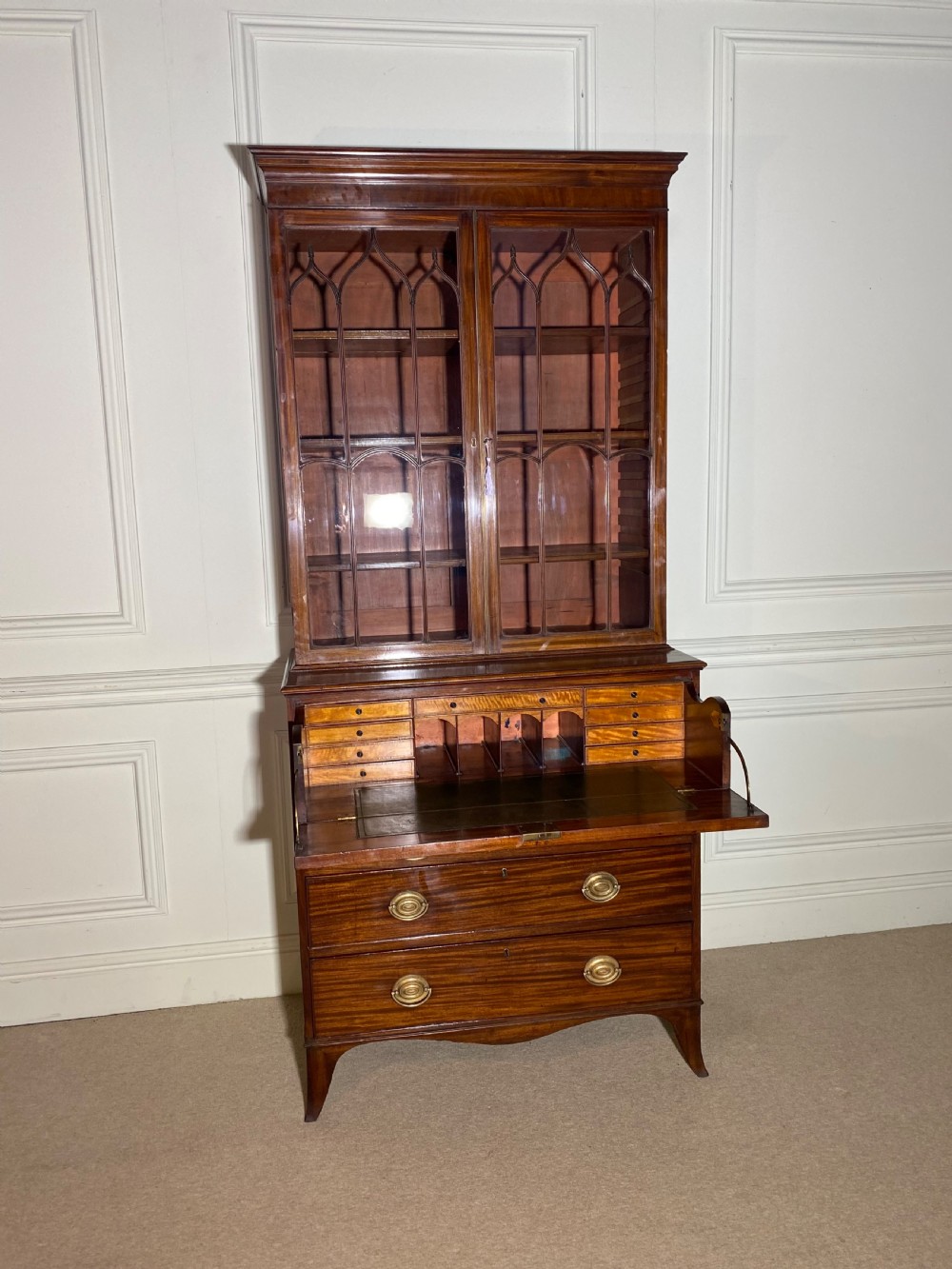 An 18th-century George III mahogany secretaire bookcase featuring an upper double-door glazed cabinet with arched astragal glazing, an open drop-front writing drawer with internal pigeonholes, and lower drawers with brass oval handles. View III