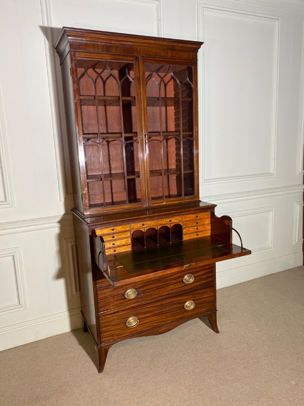 An 18th-century George III mahogany secretaire bookcase featuring an upper double-door glazed cabinet with arched astragal glazing, an open drop-front writing drawer with internal pigeonholes, and lower drawers with brass oval handles. View VI