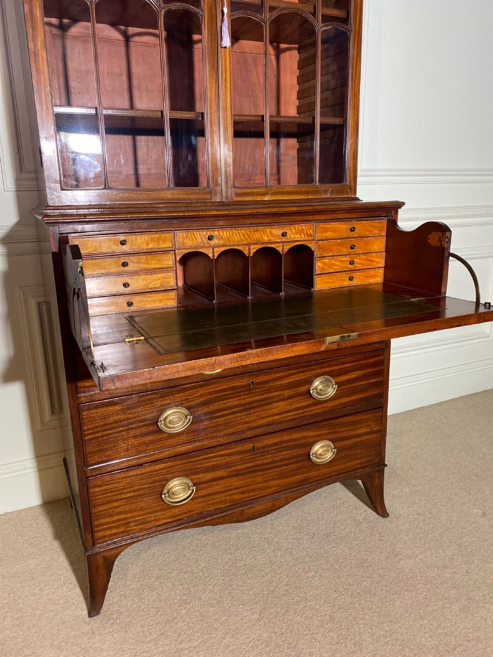 An 18th-century George III mahogany secretaire bookcase featuring an upper double-door glazed cabinet with arched astragal glazing, an open drop-front writing drawer with internal pigeonholes, and lower drawers with brass oval handles. View VII