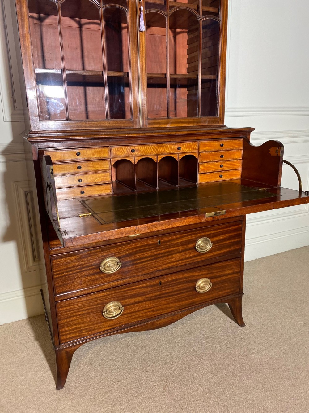 An 18th-century George III mahogany secretaire bookcase featuring an upper double-door glazed cabinet with arched astragal glazing, an open drop-front writing drawer with internal pigeonholes, and lower drawers with brass oval handles. View VIII