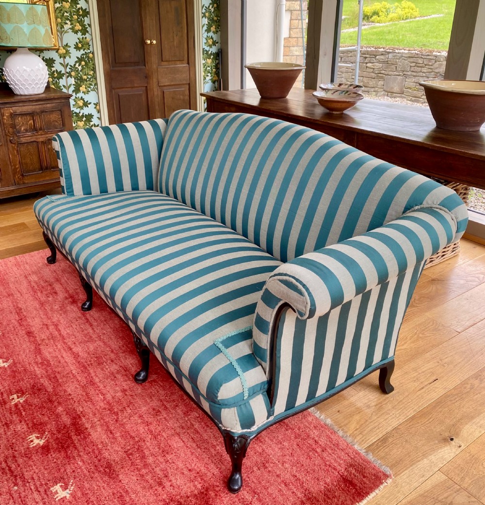 A 19th-century scroll arm sofa upholstered in green and beige striped fabric with dark carved cabriole legs. View VI