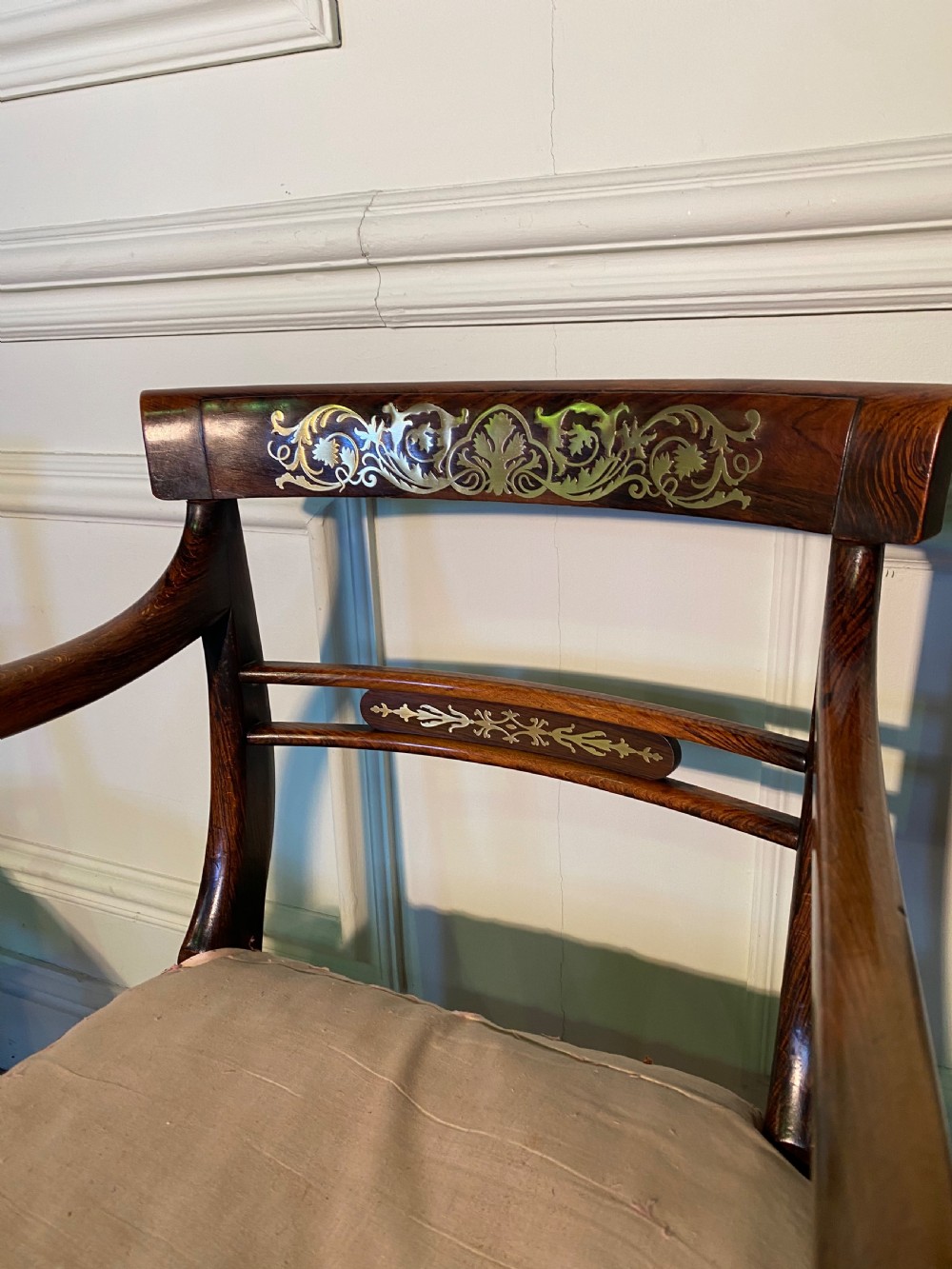 A set of Regency wooden dining chairs featuring brass inlay on the top rails, turned fluted legs, and upholstered drop-in seats. View IX