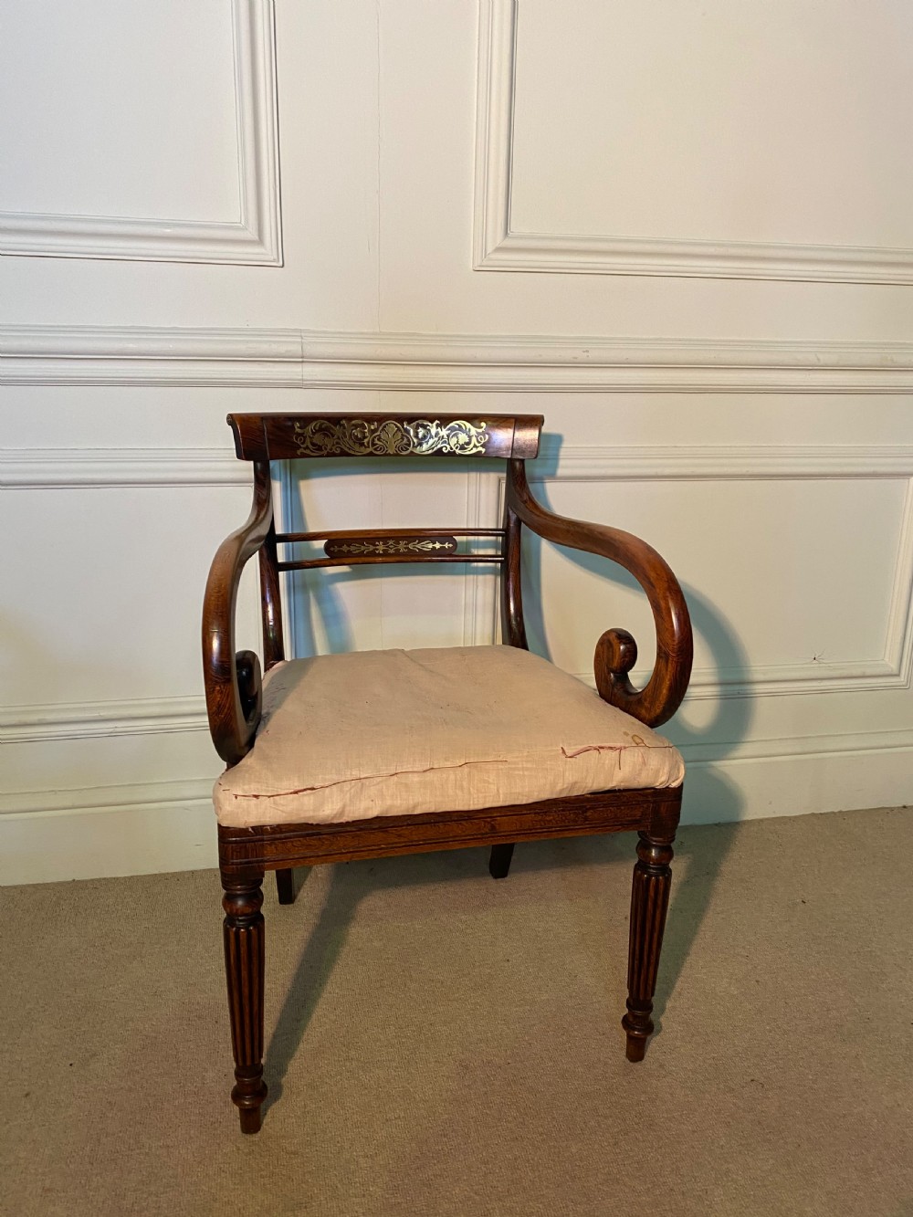 A set of Regency wooden dining chairs featuring brass inlay on the top rails, turned fluted legs, and upholstered drop-in seats. View X