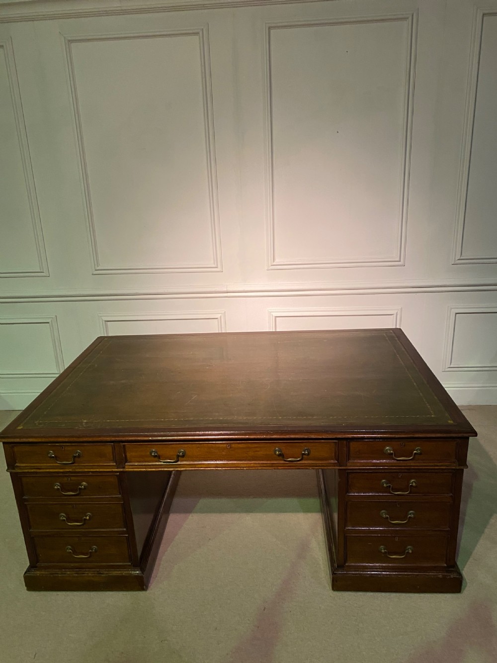 A nineteenth-century mahogany partners desk featuring a green leather inset writing surface, twin drawer pedestals, and brass drop handles. View II