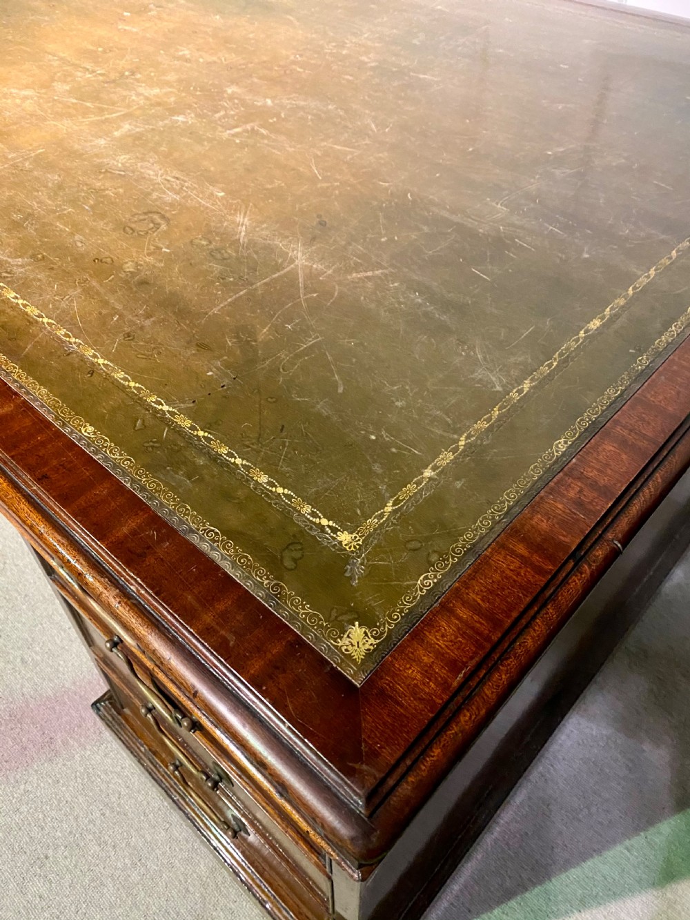 A nineteenth-century mahogany partners desk featuring a green leather inset writing surface, twin drawer pedestals, and brass drop handles. View III