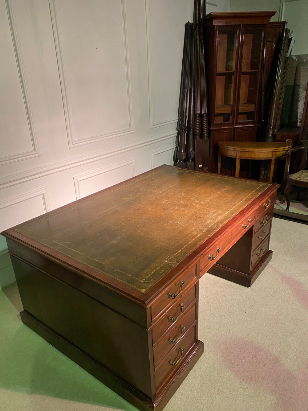 A nineteenth-century mahogany partners desk featuring a green leather inset writing surface, twin drawer pedestals, and brass drop handles. View VIII
