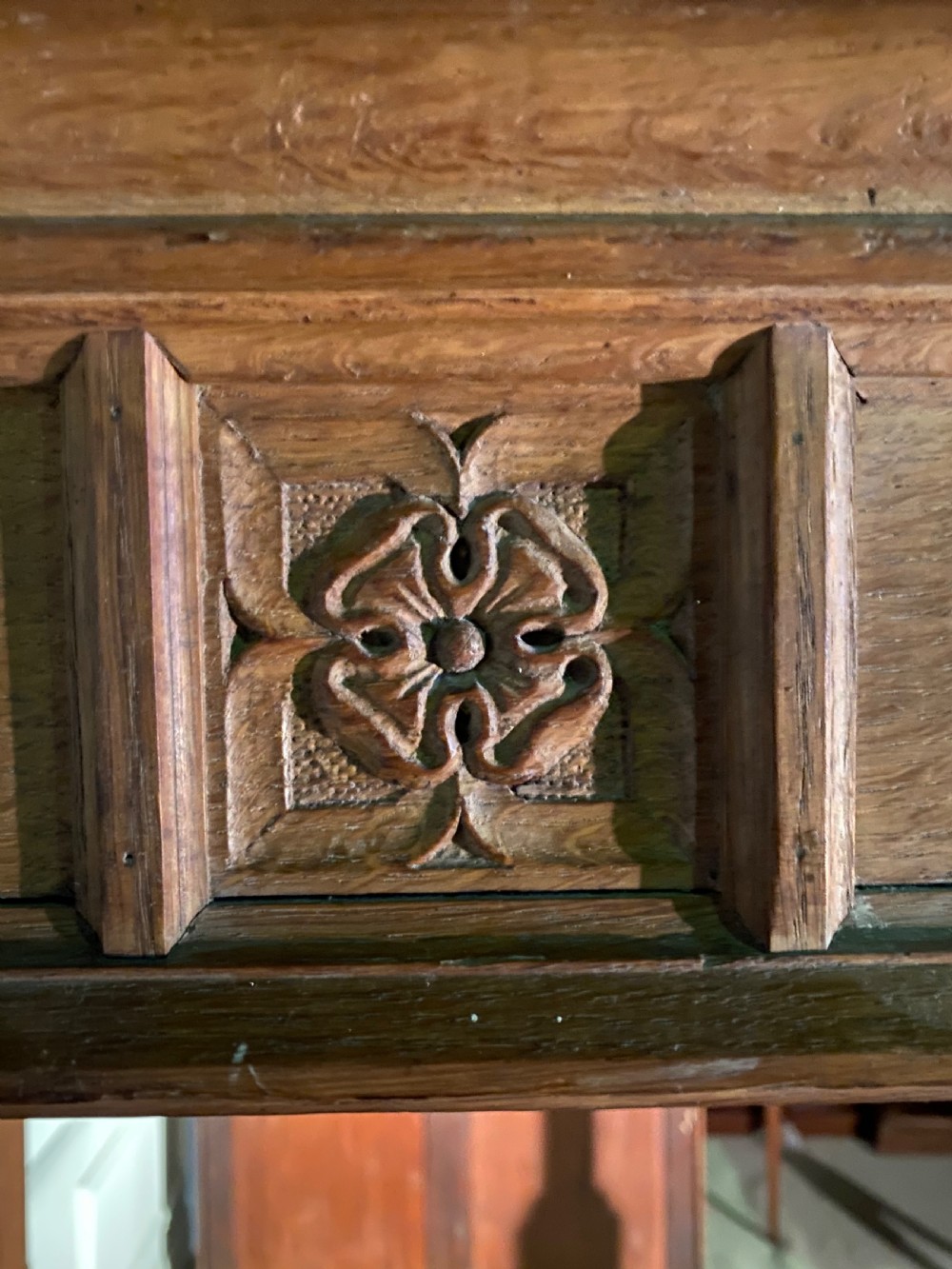An Arts and Crafts oak four poster bed frame featuring carved upright posts and a decorative upper frieze canopy structure. View V